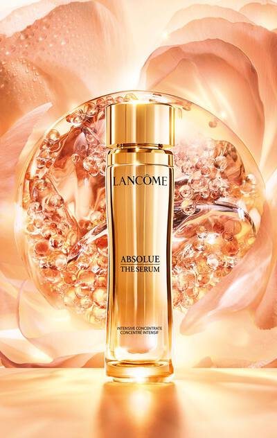 Lancome Absolue The Serum, infused with Absolue Perpetual Rose, set against a blooming rose background
