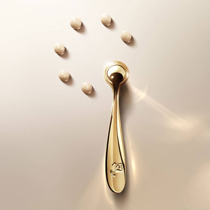 Golden Lancome applicator with The Eye Cream droplets.