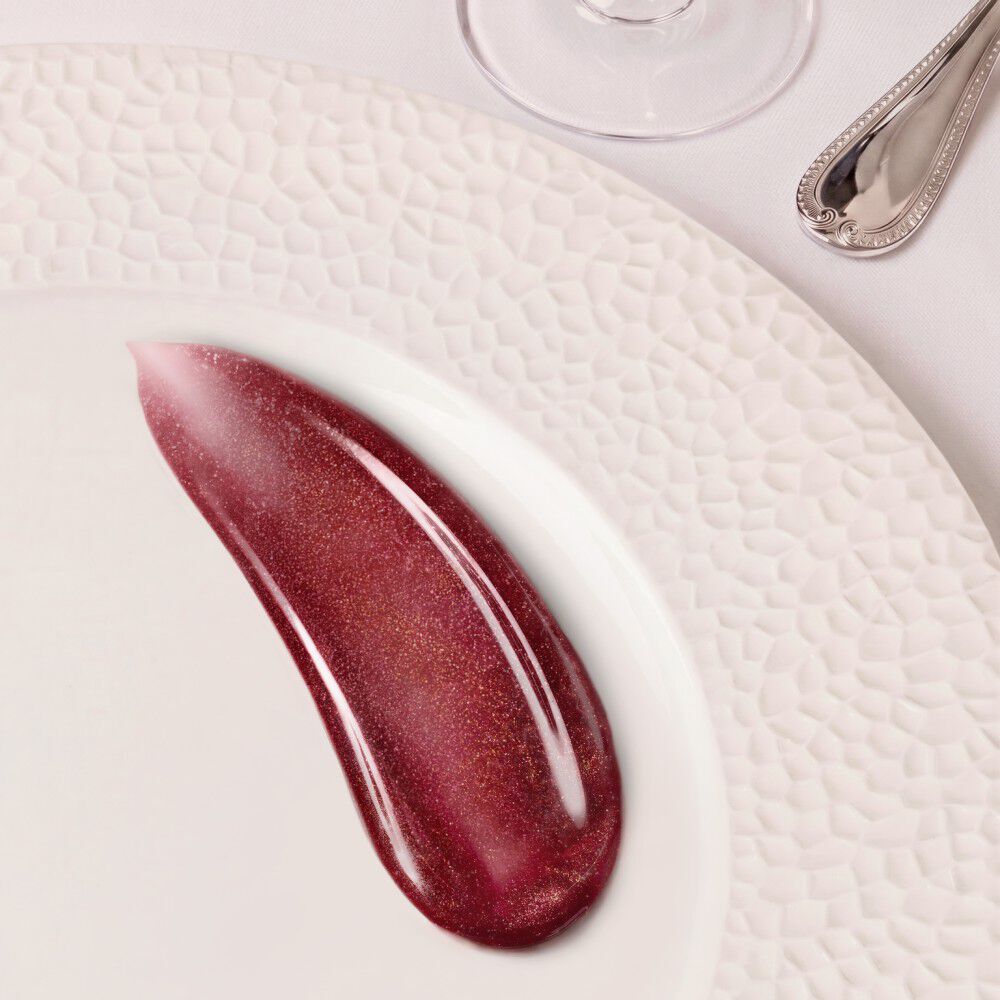 A shimmering berry cosmetic swatch on a white plate.	