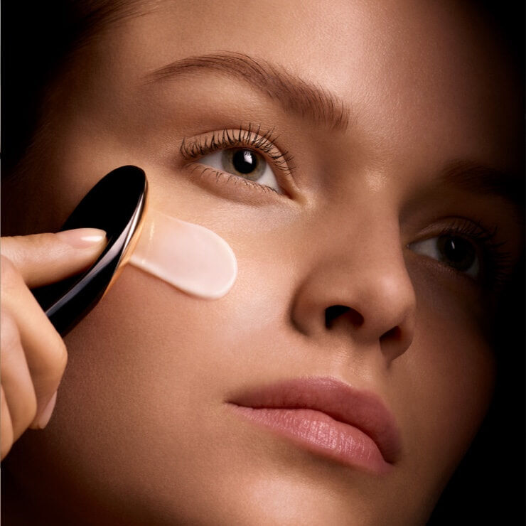 Model applying Lancome Absolue L'Extrait cream to the face using with applicator