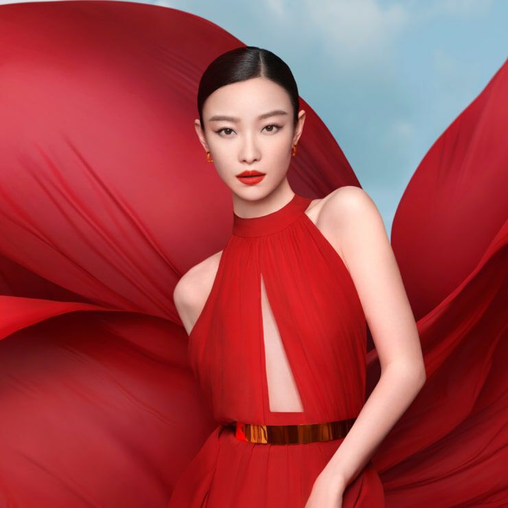 Model in red gown promoting Lancome Absolue Soft Cream Chinese New Year Limited Edition with flowing fabric background.