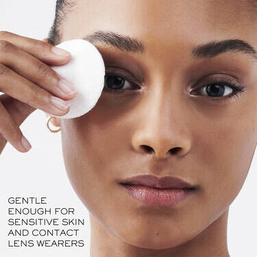 Model gently removing makeup with Lancome Bi-Facil, suitable for sensitive skin and contact lens wearers
