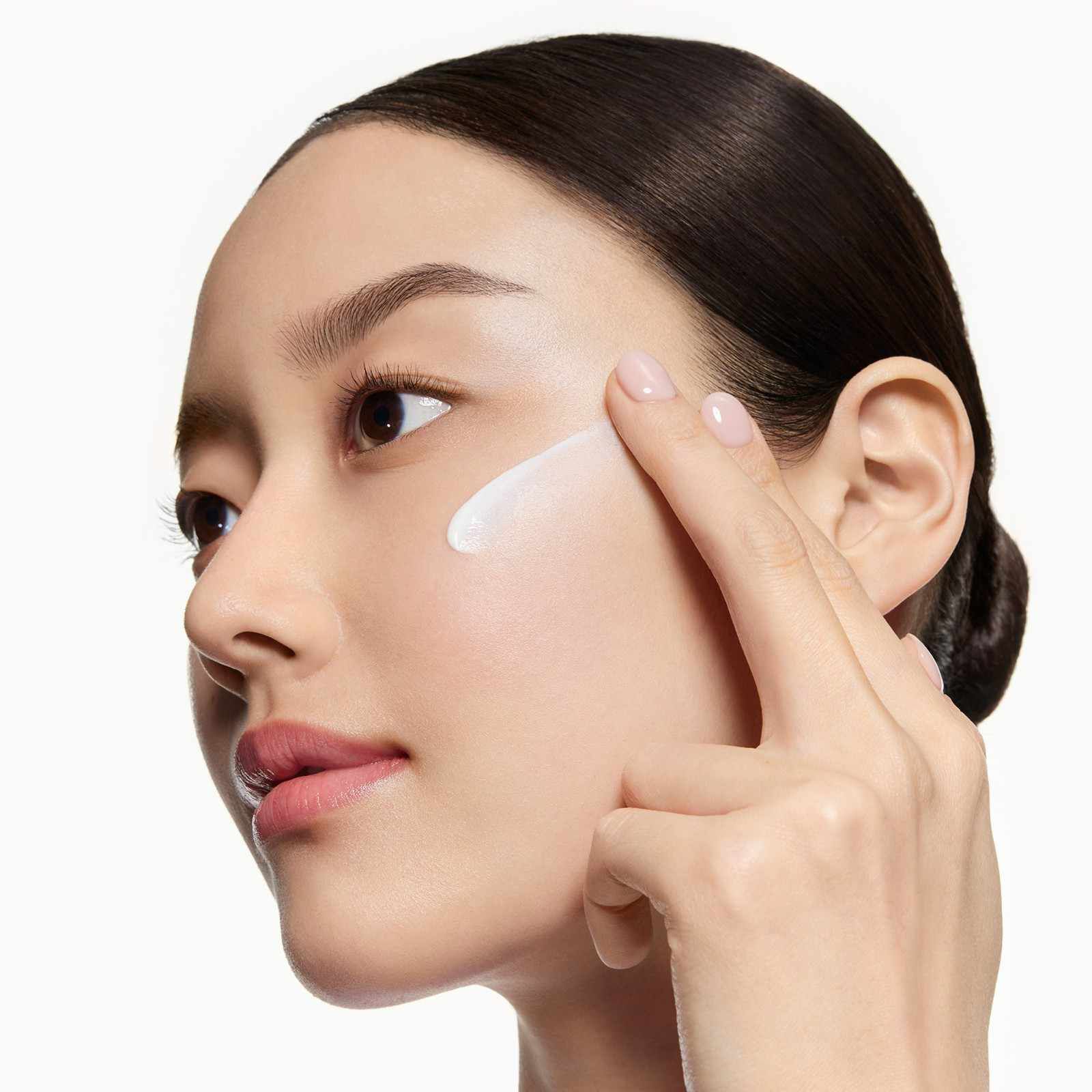 MODEL APPLYING UV EXPERT M.E.D. SHIELD SPF 50+ ON THE FACE