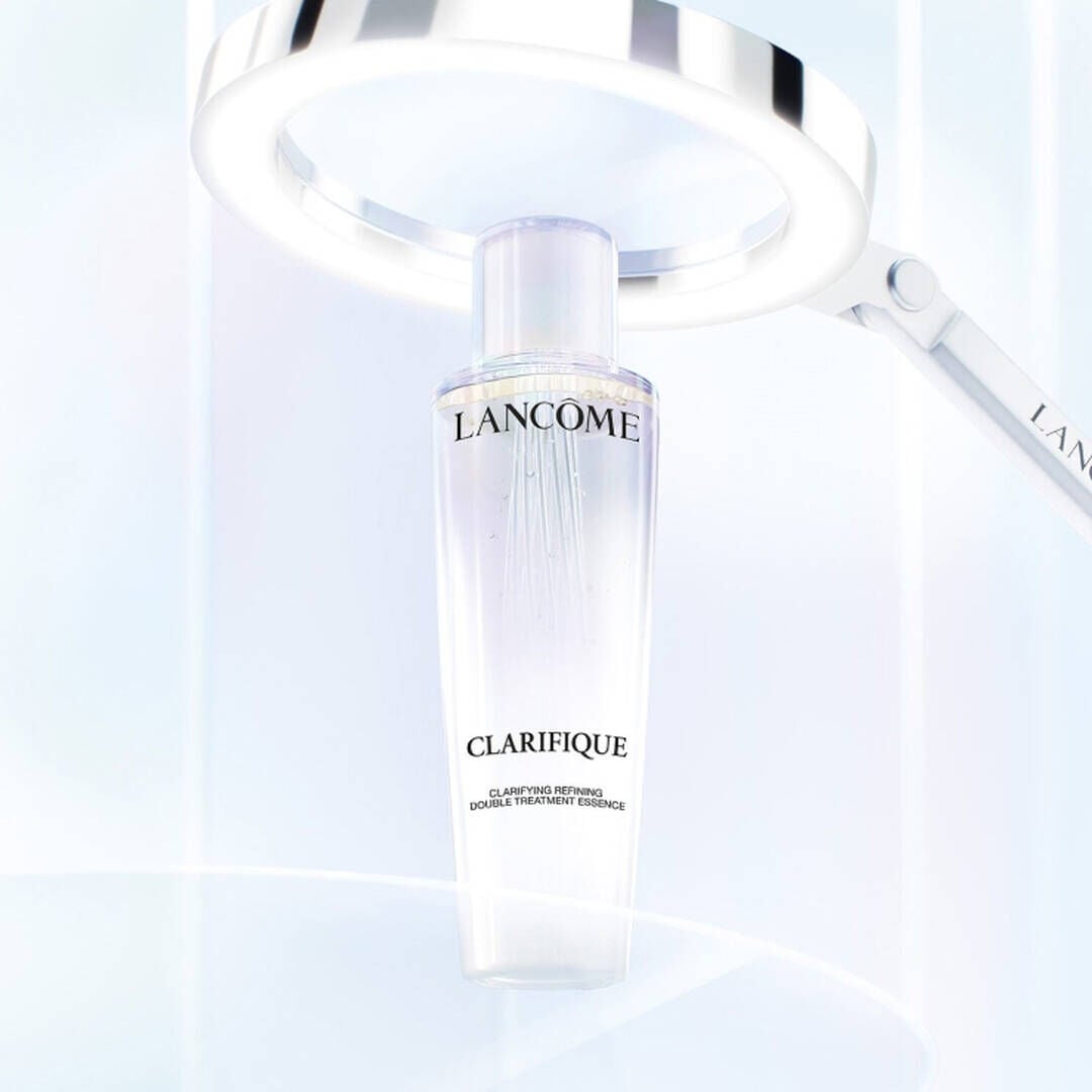 Lancome Clarifique Double Treatment Essence under a light magnifier - Showcasing its innovative bi-phase formula for skin clarity.