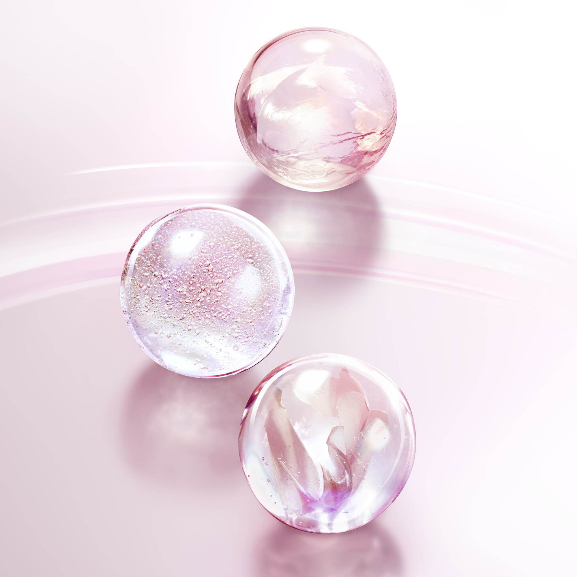 Lancome Tonique Confort toner bottle placed against a soft, pink textured background, emphasizing its creamy, hydrating formula for comfort and moisture.